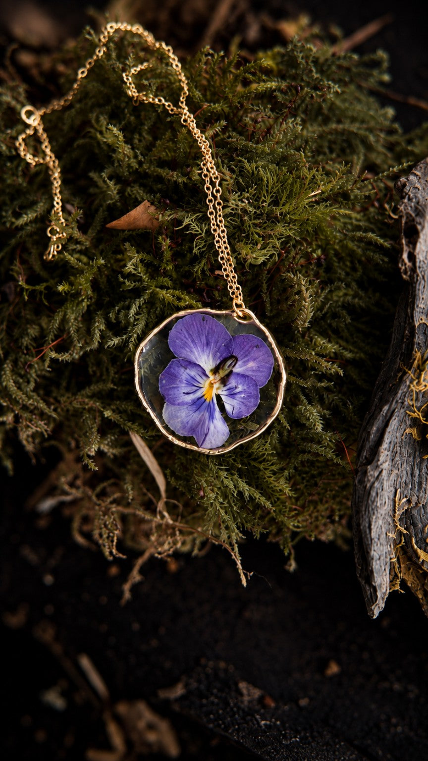 Iselia, collier Olibria avec une véritable pensée violette cultivée à l’atelier et préservée en résine transparente, monture et chaîne en acier inoxydable doré.