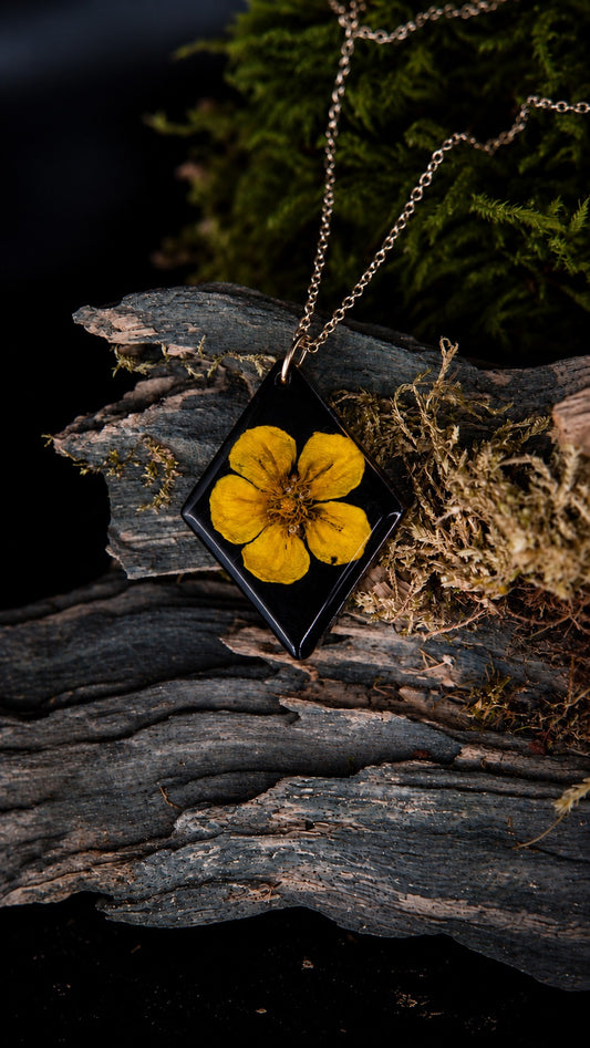Soléa, collier avec véritable bouton d’or dans un pendentif losange en résine noire